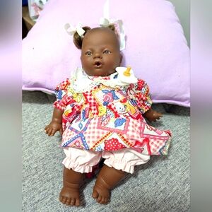 African doll with clothes and a soother. Unbranded. Cloth and plastic.